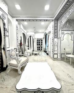 een kleedkamer met een groot wit bed en meubilair bij Lalluji Luxe in Jaipur