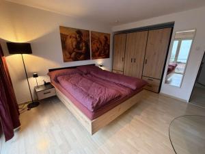 een slaapkamer met een groot bed met een paarse sprei bij Centurio 5 in Baselaugst