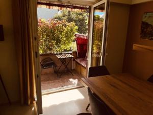 een kamer met een deur naar een patio met een tafel bij Centurio 5 in Baselaugst