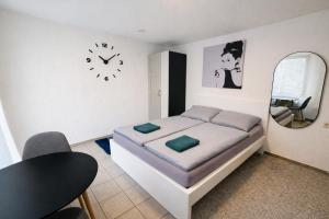 una camera da letto con un letto e un orologio sul muro di Kleines Apartment mit Doppelbett a Coblenza