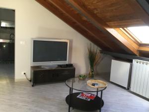 - un salon avec une télévision et une table dans l'établissement La Mansarda Sul Mare, à Bogliasco