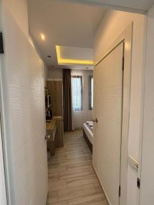 ein Flur eines Hotelzimmers mit einem Bett und einer Tür in der Unterkunft Sardunya Andifli Otel in Kaş