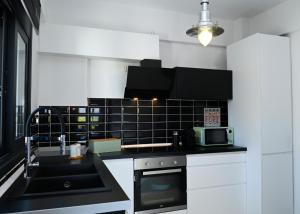 a kitchen with black and white tile on the wall at Hydra House Nafplio in Myloi