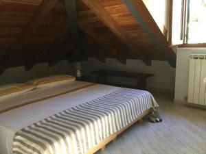 La Mansarda Sul Mare في بولياسكو: سرير في غرفة ذات سقف خشبي