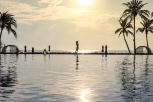七岩华欣喜来登度假村及水疗中心的站在棕榈树游泳池旁的人