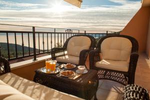 a balcony with two chairs and a table with food on it at Villa Berina in Makarska