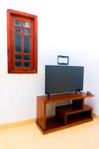 a flat screen tv sitting on a table in a room at Bentota Backpackers Bay Hostel in Bentota