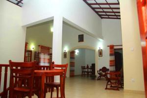 a dining room with a table and some chairs at Bentota Backpackers Bay Hostel in Bentota