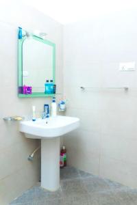 a white bathroom with a sink and a mirror at Bentota Backpackers Bay Hostel in Bentota +32 photos