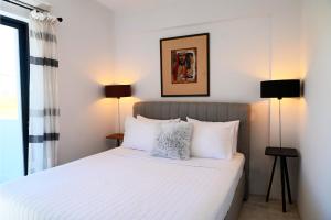 a bedroom with a white bed with two lamps at Hydra House Nafplio in Myloi