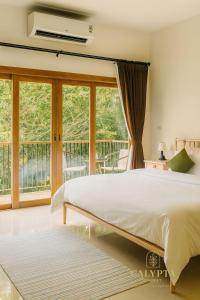 een slaapkamer met een groot bed en een balkon bij Calypta Resort Phuket in Phuket