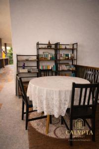 een tafel met twee stoelen en een plank met boeken bij Calypta Resort Phuket in Phuket