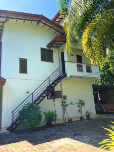 a white house with stairs on the side of it at Bentota Backpackers Bay Hostel in Bentota