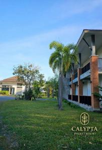 een gebouw met een palmboom voor een tuin bij Calypta Resort Phuket in Phuket +10 foto's