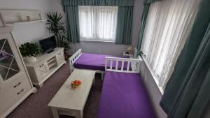 a bedroom with a purple bed and a table at Ferienwohnung Bergstraße Hammermühle in Bad Düben