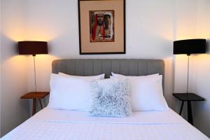 a bedroom with a white bed with two lamps at Hydra House Nafplio in Myloi +17 photos