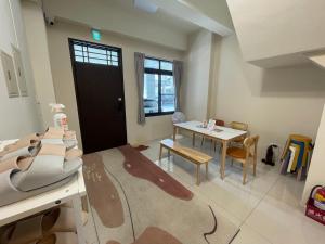 Zimmer mit einem Tisch, einem Tisch und Stühlen in der Unterkunft Hello Guesthouse in Lukang