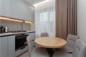 a small kitchen with a wooden table and chairs at HomeRent Petru Zadnipru in Chişinău