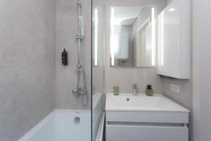 a bathroom with a white sink and a shower at HomeRent Petru Zadnipru in Chişinău +19 photos