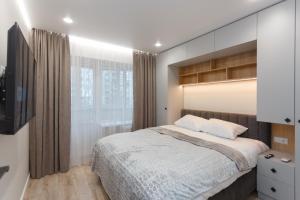 a bedroom with a bed and a television in it at HomeRent Petru Zadnipru in Chişinău