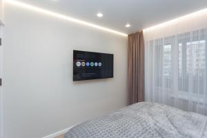 a bedroom with a tv on the wall next to a bed at HomeRent Petru Zadnipru in Chişinău