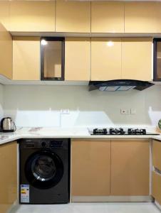 a kitchen with a washing machine and a stove at The Colony in Mama