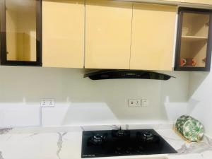 a kitchen with a black stove top and cabinets at The Colony in Mama +5 photos