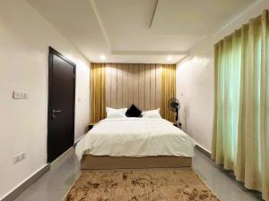 a bedroom with a large bed with a wooden headboard at The Colony in Mama
