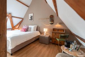 een slaapkamer op zolder met een bed en een tafel bij Hotel het Oude Raadhuis in Castricum