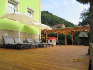 eine Terrasse mit Bänken und Sonnenschirmen auf einem Gebäude in der Unterkunft Villa Arizona in Bad Schandau