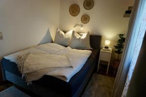 a bedroom with a bed with white sheets and pillows at Bergnest Fieberbrunn in Fieberbrunn