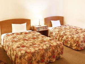 Postel nebo postele na pokoji v ubytování 寝屋川トレンドホテル