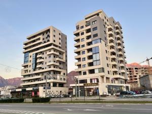 twee hoge witte gebouwen naast een straat bij Alula Apartments in Bar