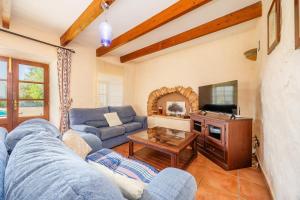 un soggiorno con un divano blu e una TV di Mirabo ramonet a Caʼs Concos