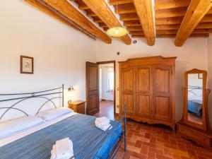 een slaapkamer met een bed en een houten plafond bij Apartment in a farmhouse with 2 swimming pools in Cagli