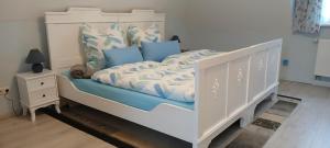 ein Schlafzimmer mit einem weißen Bett mit blauen Kissen in der Unterkunft Kutscherhaus Werdau in Werdau