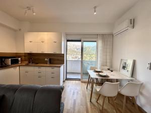 een keuken en eetkamer met een tafel en stoelen bij Alula Apartments in Bar