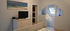 ein Zimmer mit einer Kommode mit einem Fernseher drauf in der Unterkunft Kutscherhaus Werdau in Werdau