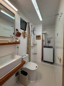 Aqua Horizon Beachside Skyline Vista Art Condominium في داويس: حمام مع حوض ومرحاض ومرآة