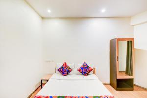 une chambre avec un lit avec deux oreillers dessus dans l'établissement FabHotel White Ridge Chaitanyapuri, à Hyderabad