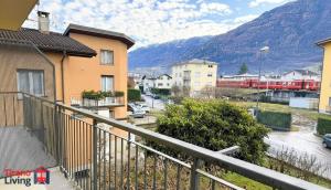 a train is traveling through a town with houses at Carbonera 4 - casetta vicina alla Stazione in Tirano