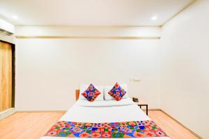 - une chambre avec un lit et des oreillers colorés dans l'établissement FabHotel White Ridge Chaitanyapuri, à Hyderabad
