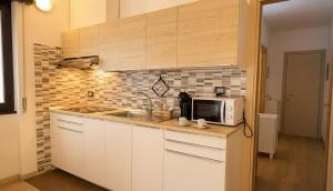 a kitchen with a sink and a microwave at Carbonera 4 - casetta vicina alla Stazione in Tirano