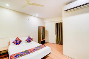 a bedroom with a bed and a ceiling fan at FabHotel White Ridge Chaitanyapuri in Hyderabad