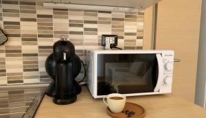 a cup of coffee sitting next to a microwave at Carbonera 4 - casetta vicina alla Stazione in Tirano