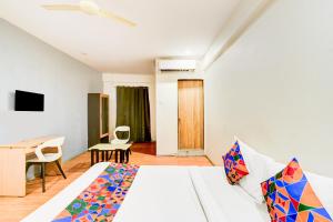a bedroom with a bed and a table and a desk at FabHotel White Ridge Chaitanyapuri in Hyderabad