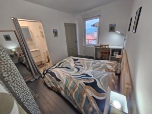 ein Schlafzimmer mit einem Bett, einem Schreibtisch und einem Spiegel in der Unterkunft Appartement F2 5B in Martres-de-Veyre + 9 Fotos