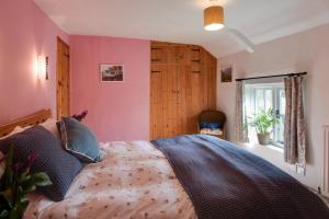 a bedroom with a large bed with pink walls at 5 Bed in Hindolveston oc-d29357 in Hindolveston