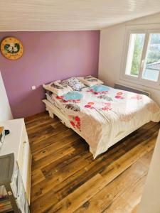 une chambre avec un lit et un parquet dans l'établissement Maison TIKI TAHITI, à Alès