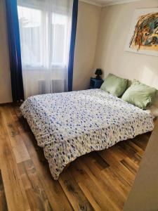 a bed sitting on a wooden floor in a bedroom at Maison TIKI TAHITI in Alès